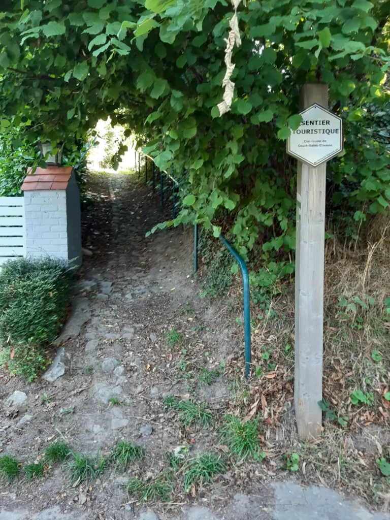 Panneau directionnel indiquant un sentier de balade touristique à Court-Saint-Etienne