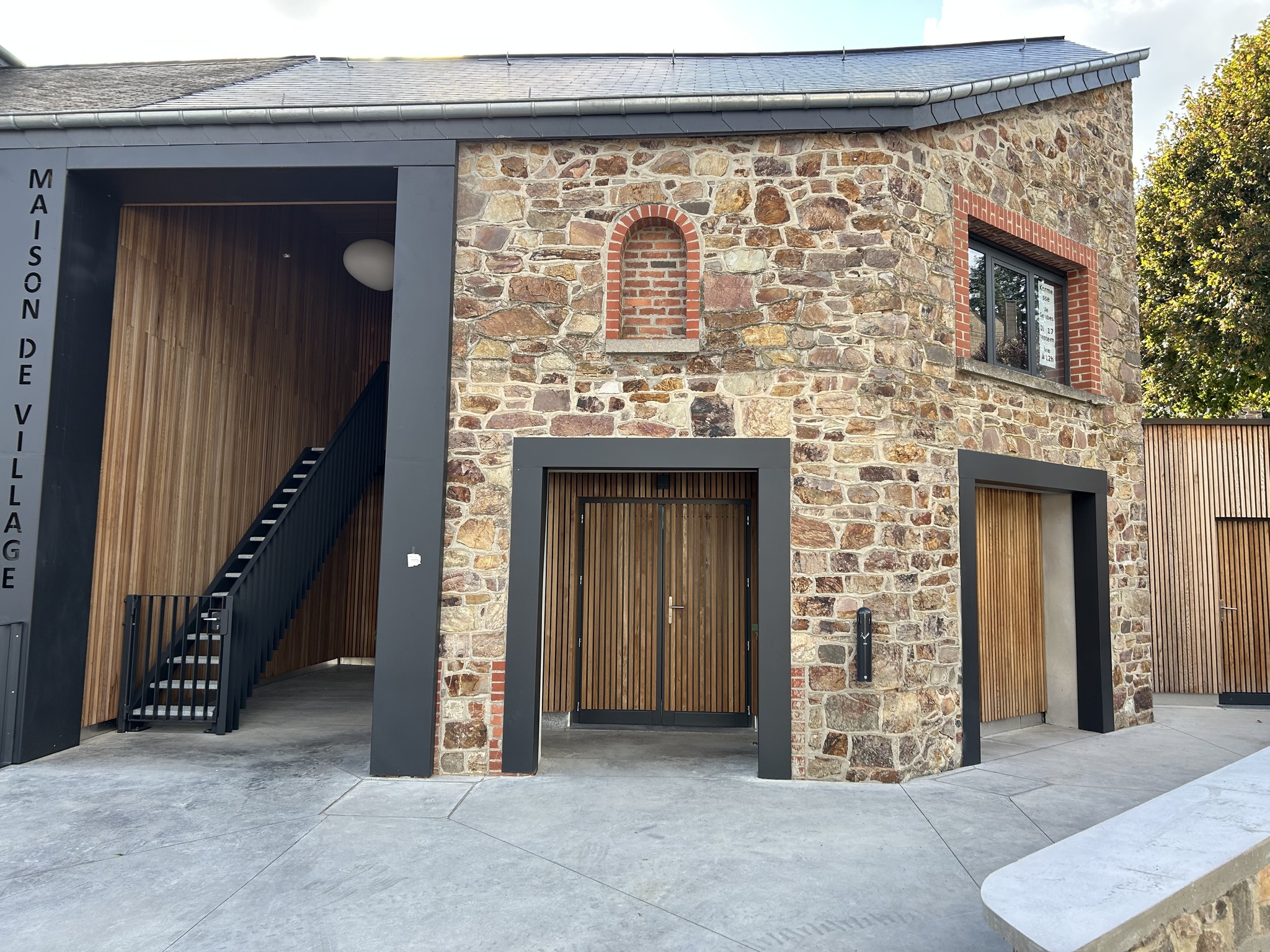 Façade noire et pierre de pays de la maison de village de Gembes