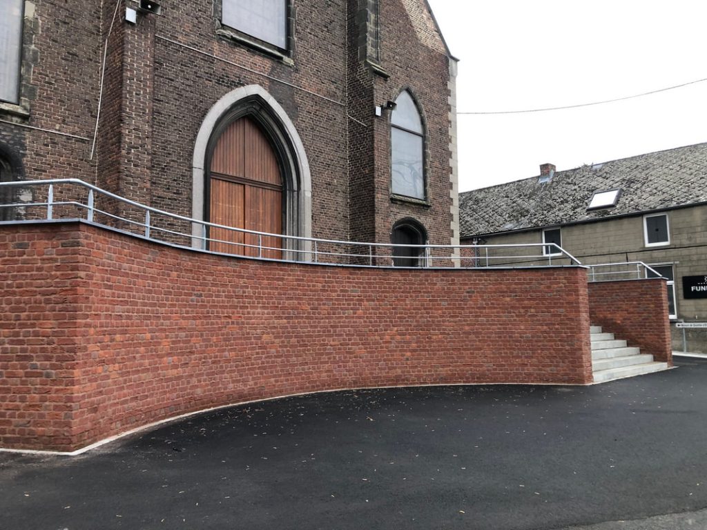Entrée de l'église d'elouges avec une rampe d’accès et escalier