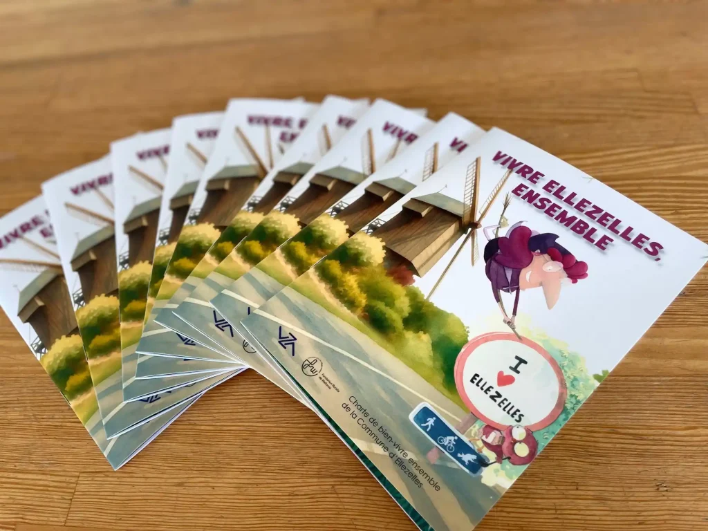 Plusieurs brochures "Vivre Ellezelles, ensemble" posées sur une table