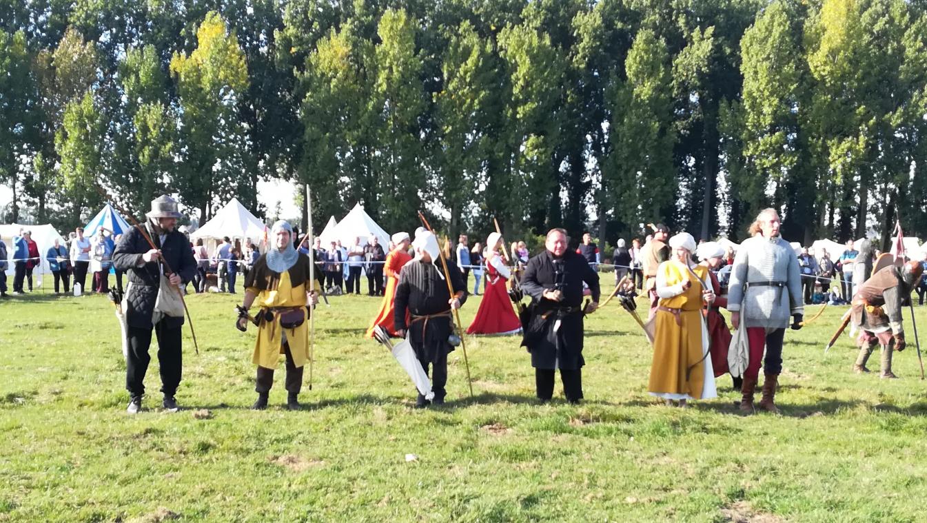 Participants en costumes médiévaux lors d’une reconstitution historique en plein air.