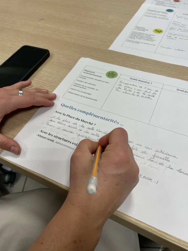 Photo représentant une personne dont on ne voit que les mains en train de compléter un document aidant à la précision des idées de projets.