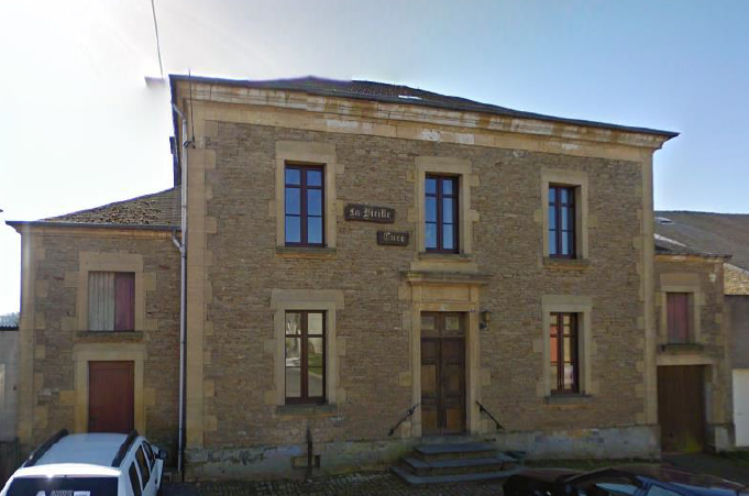 Photo représentant la façade de la Vieille Cure, salle bien connue des habitants. Façade toute en pierre brute avec des châssis en bois foncé.