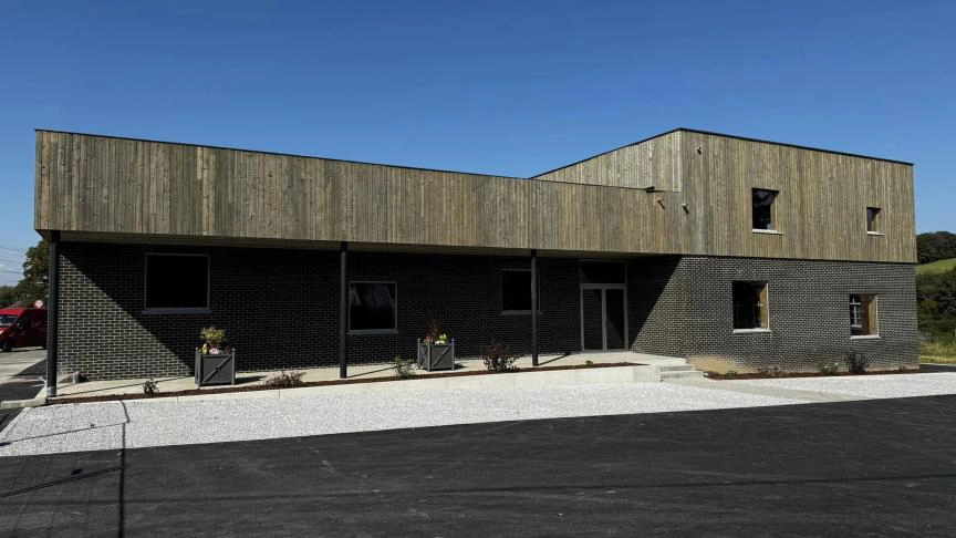 Maison de Village de Grandrieu, bâtiment moderne en bois et briques inauguré le 22 septembre 2024, sous un ciel dégagé.