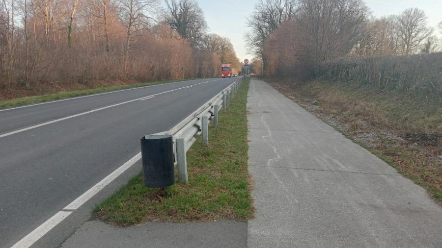 Vue de la double voie à Sivry-Rance après les travaux de sécurisation. L’image montre une route bordée d’une glissière métallique et d’un chemin en béton, entourée de végétation hivernale.