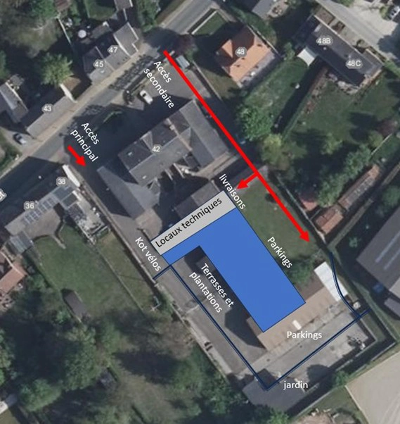 Vue aérienne d’un site comprenant plusieurs bâtiments, avec indications graphiques des accès, zones de livraison, parkings, locaux techniques, terrasse et jardin.