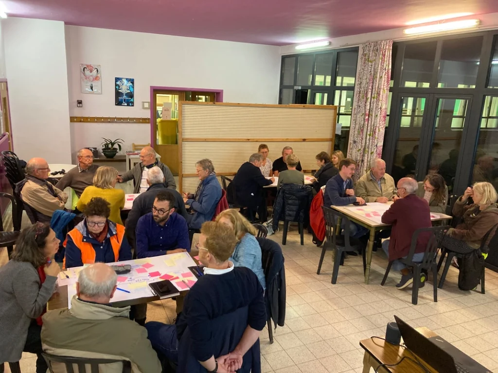 Réunion participative avec plusieurs groupes de citoyens discutant des projets pour le développement rural.