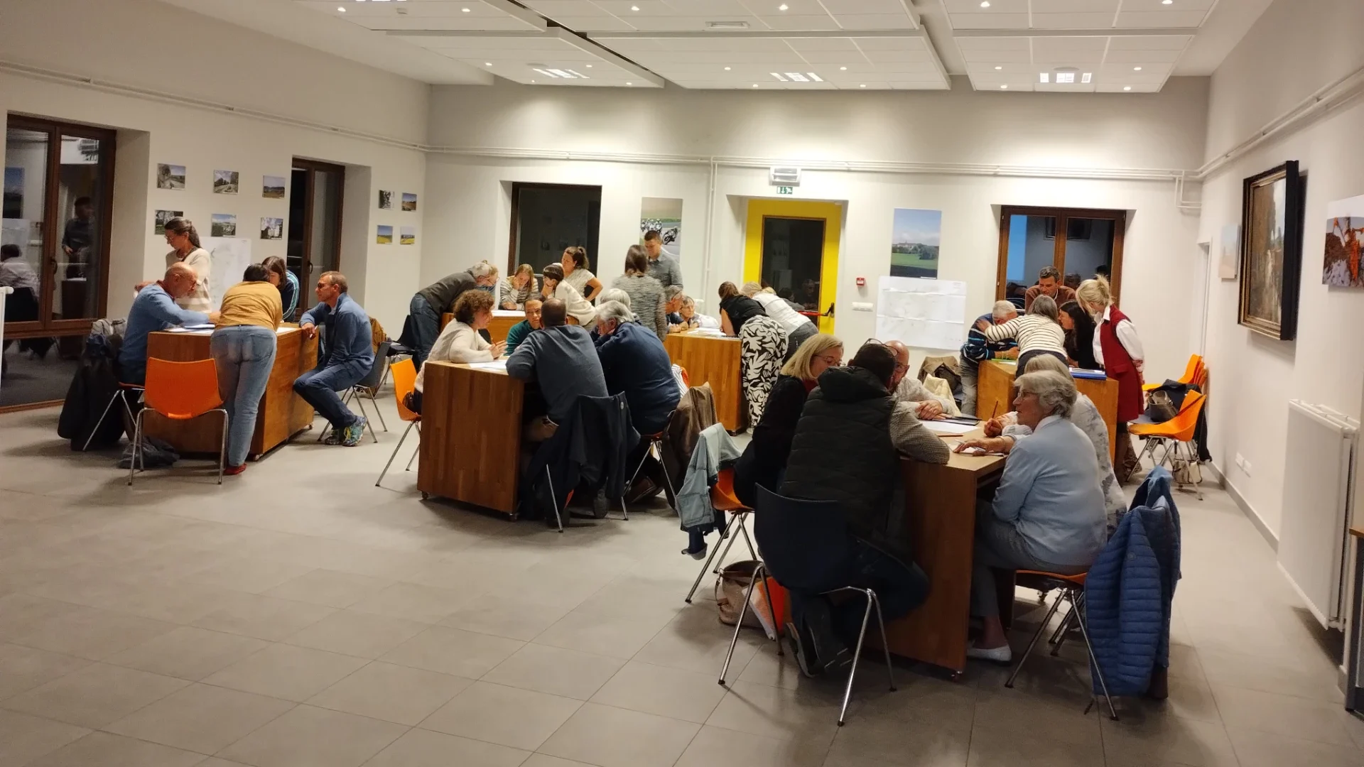 Plusieurs groupes de citoyens et d’acteurs locaux discutent et travaillent sur des documents autour de tables. Ils sont réunis lors d’une séance de travail de l’Opération de Développement Rural de Mettet lors d'une réunion animée par la FRW.